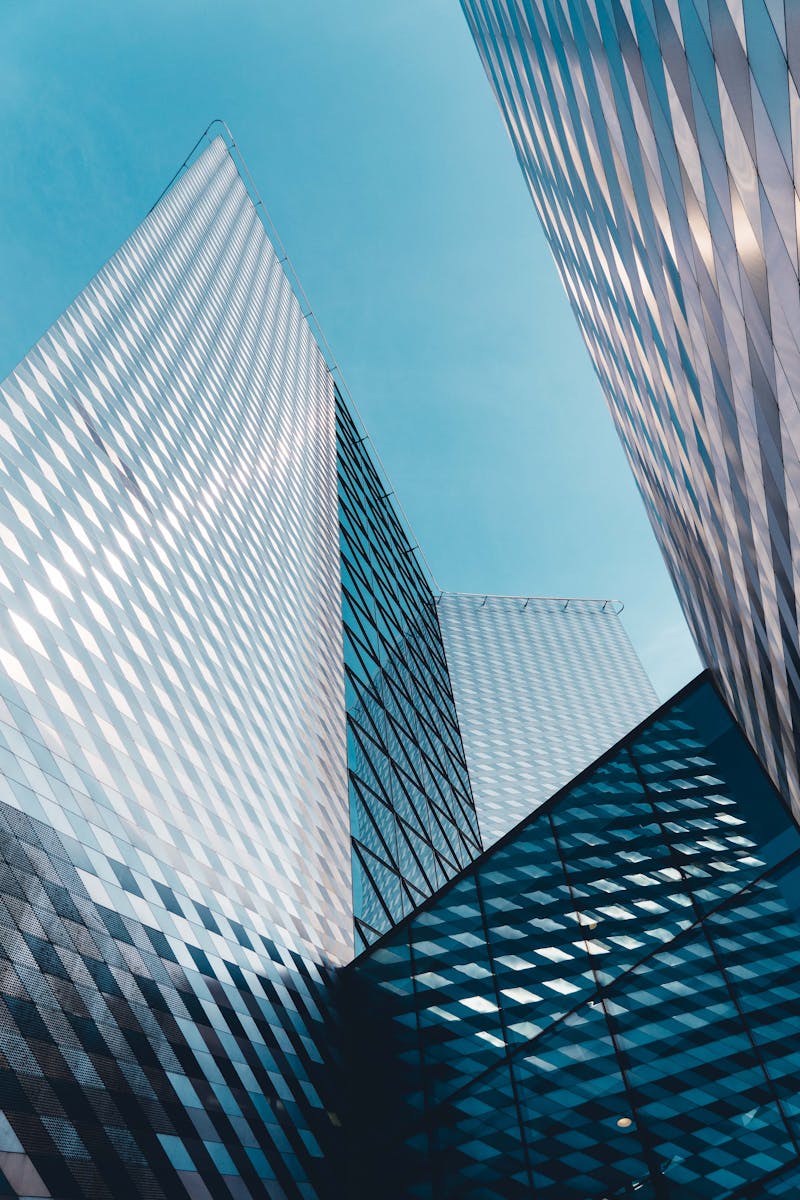 Futuristic skyscrapers in Vilnius with reflective geometric facades under a clear sky.